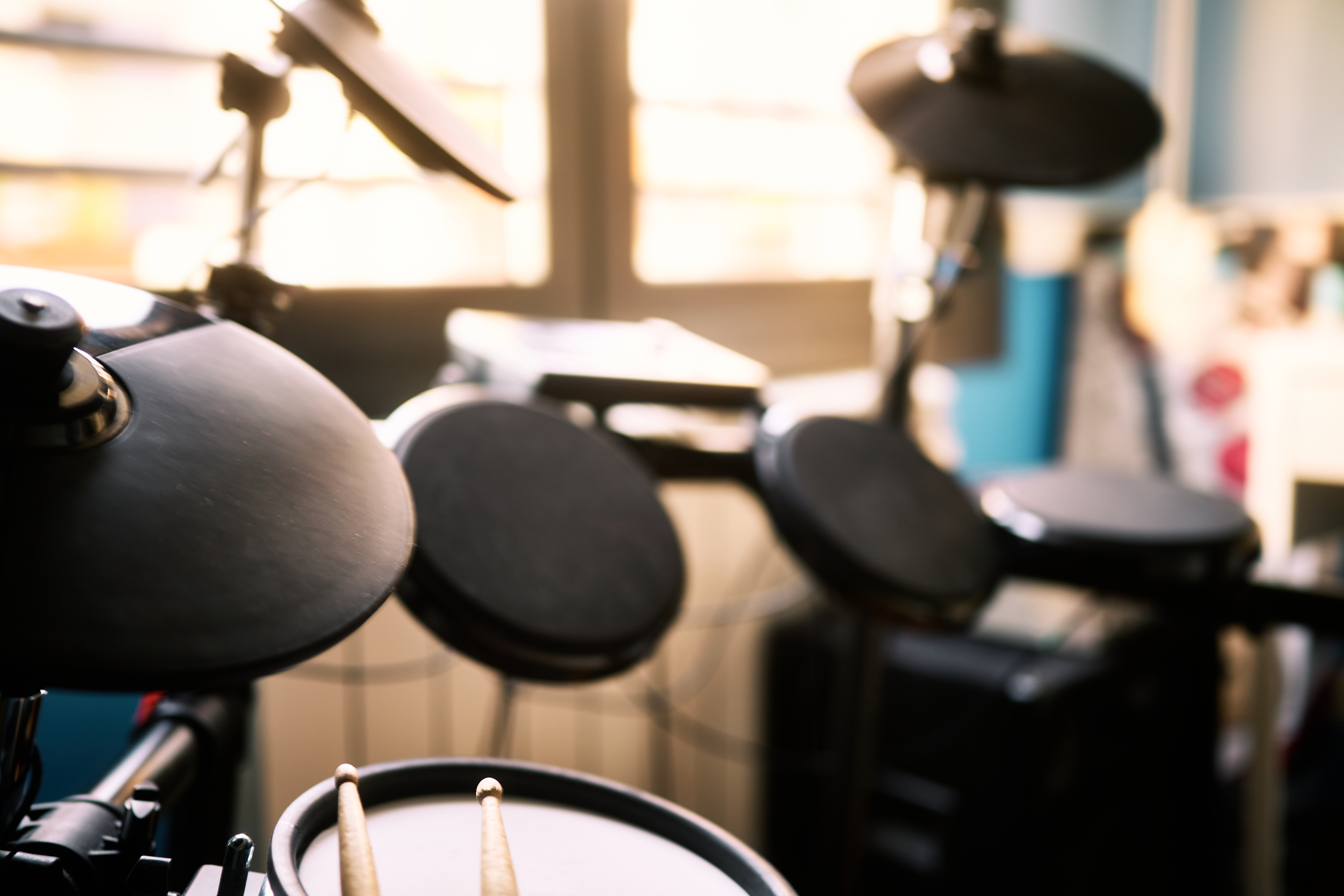 Drumstick and electric battery located in front of the window in a house